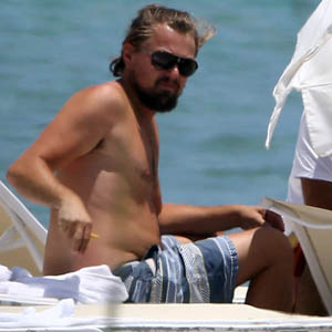 Exclusive... 51481469 'Wolf Of Wall Street' actor Leonardo DiCaprio relaxes beachside in Miami, Florida on July 19, 2014. Leo is spotted removing his t-shirt and exposing his un-toned stomach while smoking a cigarette. FameFlynet, Inc - Beverly Hills, CA, USA - +1 (818) 307-4813