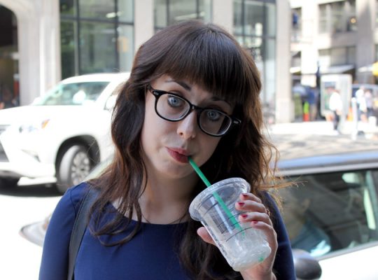 woman drinking iced coffee