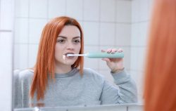woman brushing with toothpaste down chin