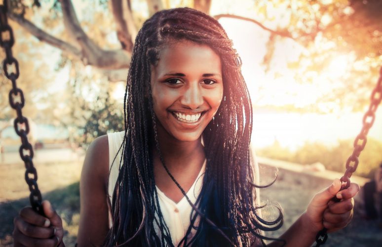 woman smiling with thin box braids