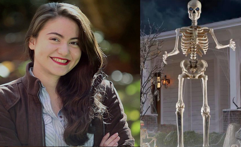 woman proud next to 12 foot home depot skeleton